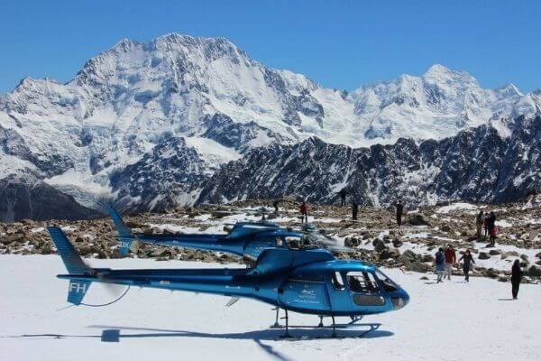 Two helicopters in front of mountain
