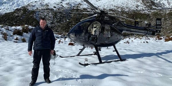 Gus Gordon standing in front of a black helicopter