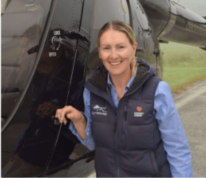 Rachel Button standing by helicopter